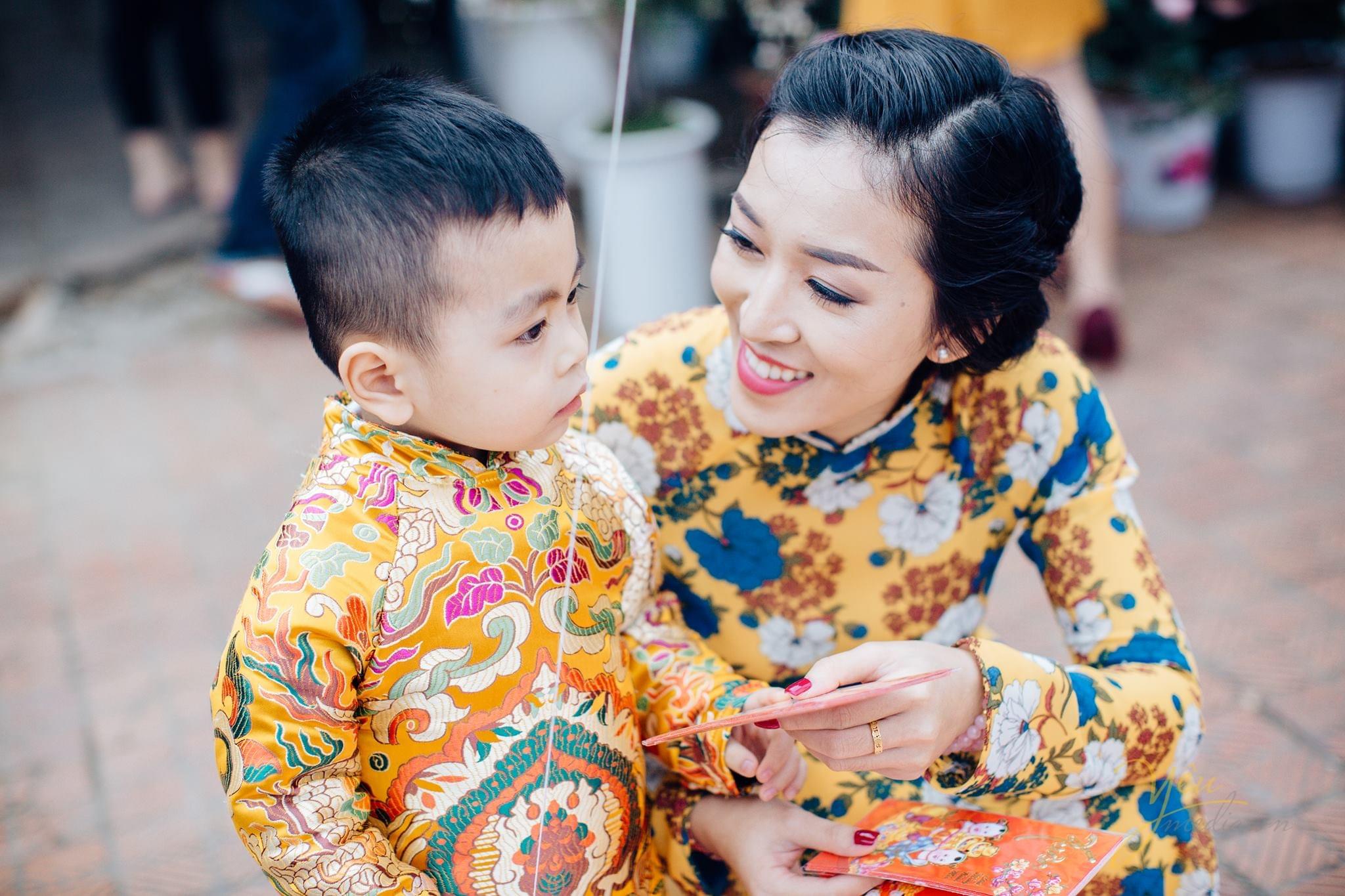 mẹ và bé mặc áo dài gấm màu vàng du xuân chụp ảnh