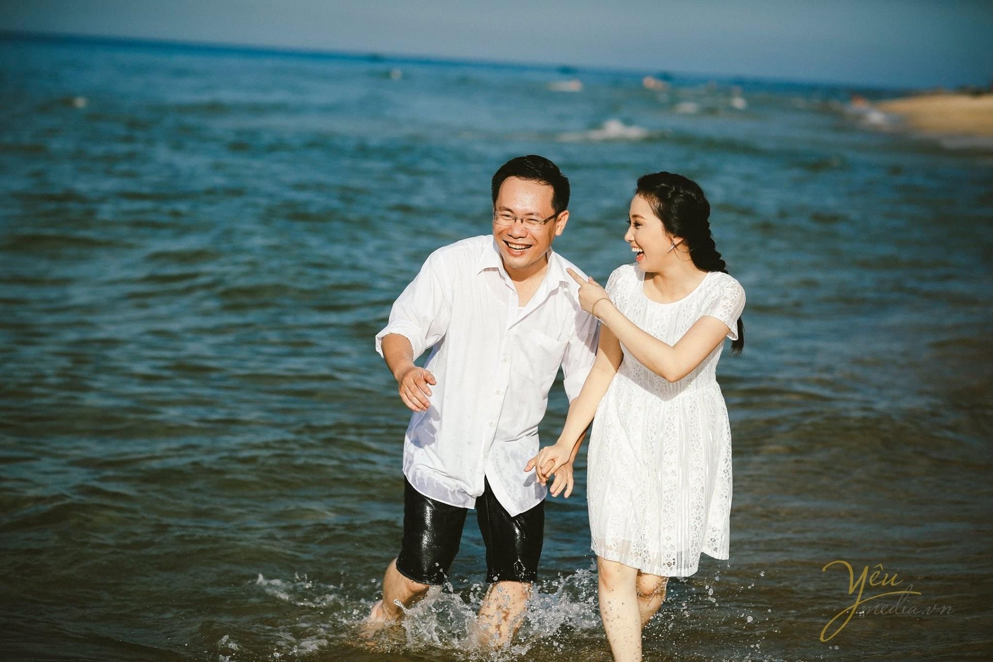 chú rể cô dâu cười đùa lội nước biển