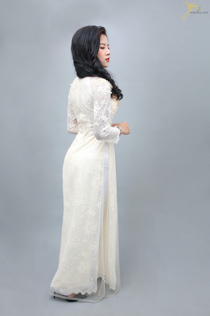 Áo dài màu kem là sự lựa chọn của nhiều cô dâu trong dịp ăn hỏi và cưới, mang đến vẻ sang trọng, nền nã.   Mẫu áo dài này của Yêu Media được rất nhiều khách hàng lựa chọn vì sự nhẹ nhàng, dịu dàng thể hiện trong từng sợi vải, từng đường thêu hoa, đính ngọc trên vai áo, ngực áo và trên hông áo.  Những bạn người mảnh mai, thon thả khi mặc bộ áo dài này sẽ tôn lên trọn vẻ đẹp cơ thể của mình.