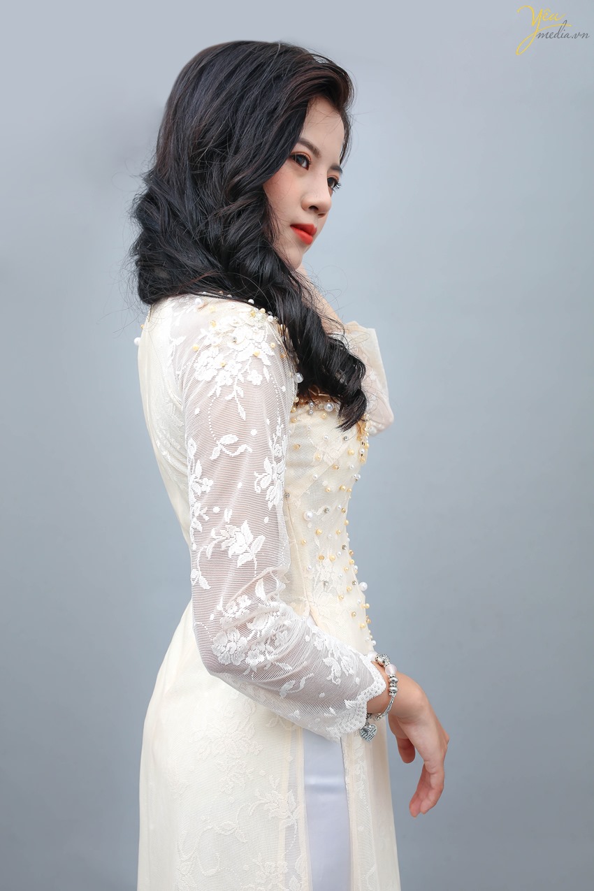 Áo dài màu kem là sự lựa chọn của nhiều cô dâu trong dịp ăn hỏi và cưới, mang đến vẻ sang trọng, nền nã.   Mẫu áo dài này của Yêu Media được rất nhiều khách hàng lựa chọn vì sự nhẹ nhàng, dịu dàng thể hiện trong từng sợi vải, từng đường thêu hoa, đính ngọc trên vai áo, ngực áo và trên hông áo.  Những bạn người mảnh mai, thon thả khi mặc bộ áo dài này sẽ tôn lên trọn vẻ đẹp cơ thể của mình.