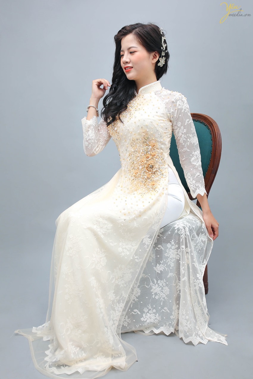 Áo dài màu kem là sự lựa chọn của nhiều cô dâu trong dịp ăn hỏi và cưới, mang đến vẻ sang trọng, nền nã.   Mẫu áo dài này của Yêu Media được rất nhiều khách hàng lựa chọn vì sự nhẹ nhàng, dịu dàng thể hiện trong từng sợi vải, từng đường thêu hoa, đính ngọc trên vai áo, ngực áo và trên hông áo.  Những bạn người mảnh mai, thon thả khi mặc bộ áo dài này sẽ tôn lên trọn vẻ đẹp cơ thể của mình.