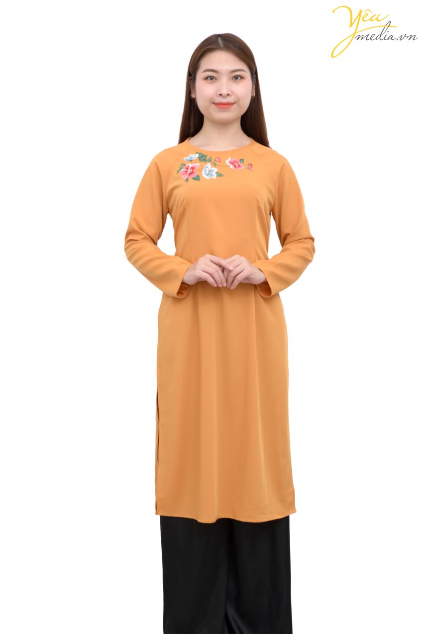 Mẫu áo dài 83 với màu cam đất truyền thống, có thiết kế đơn giản nhưng lịch lãm, được thêu phía trước ngực một nhành hoa hồng - xanh nhã nhặn. Đây là mẫu áo dài lửng đến đầu gối, được nhiều người lựa chọn để chụp hình áo dài Tết, áo dài cùng gia đình...