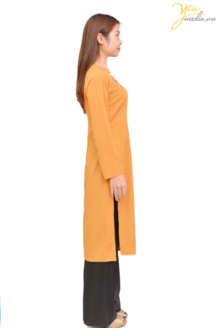 Mẫu áo dài 83 với màu cam đất truyền thống, có thiết kế đơn giản nhưng lịch lãm, được thêu phía trước ngực một nhành hoa hồng - xanh nhã nhặn. Đây là mẫu áo dài lửng đến đầu gối, được nhiều người lựa chọn để chụp hình áo dài Tết, áo dài cùng gia đình...