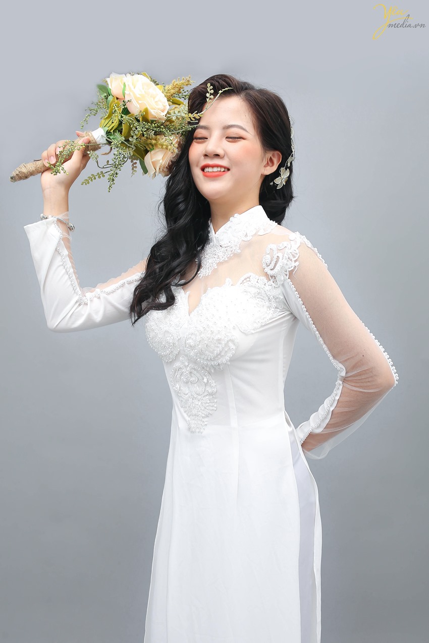 Áo dài trắng chưa bao giờ lỗi mốt. Vẻ đẹp dịu dàng, nền nã của chiếc áo dài trắng, đi cùng với chiếc quần lụa màu trắng luôn là lựa chọn hoàn hảo cho những cô nàng thích vẻ trong sáng. Từng đường nét thiết kế của chiếc áo dài đều được tính toán cẩn thận, hướng tới sự tinh tế. Chiếc cổ tàu nhẹ nhàng, khoe khéo chiếc cổ xinh xắn, giúp tôn được những nét đẹp nhẹ nhàng tiềm ẩn ở mỗi người con gái. Phía ngực của áo dài đính những đường ngọc trai hết sức sang trọng và quý phái, lớp ren mỏng trước ngực và phía sau mềm mại giúp chiếc áo dài thêm phần cuốn hút.