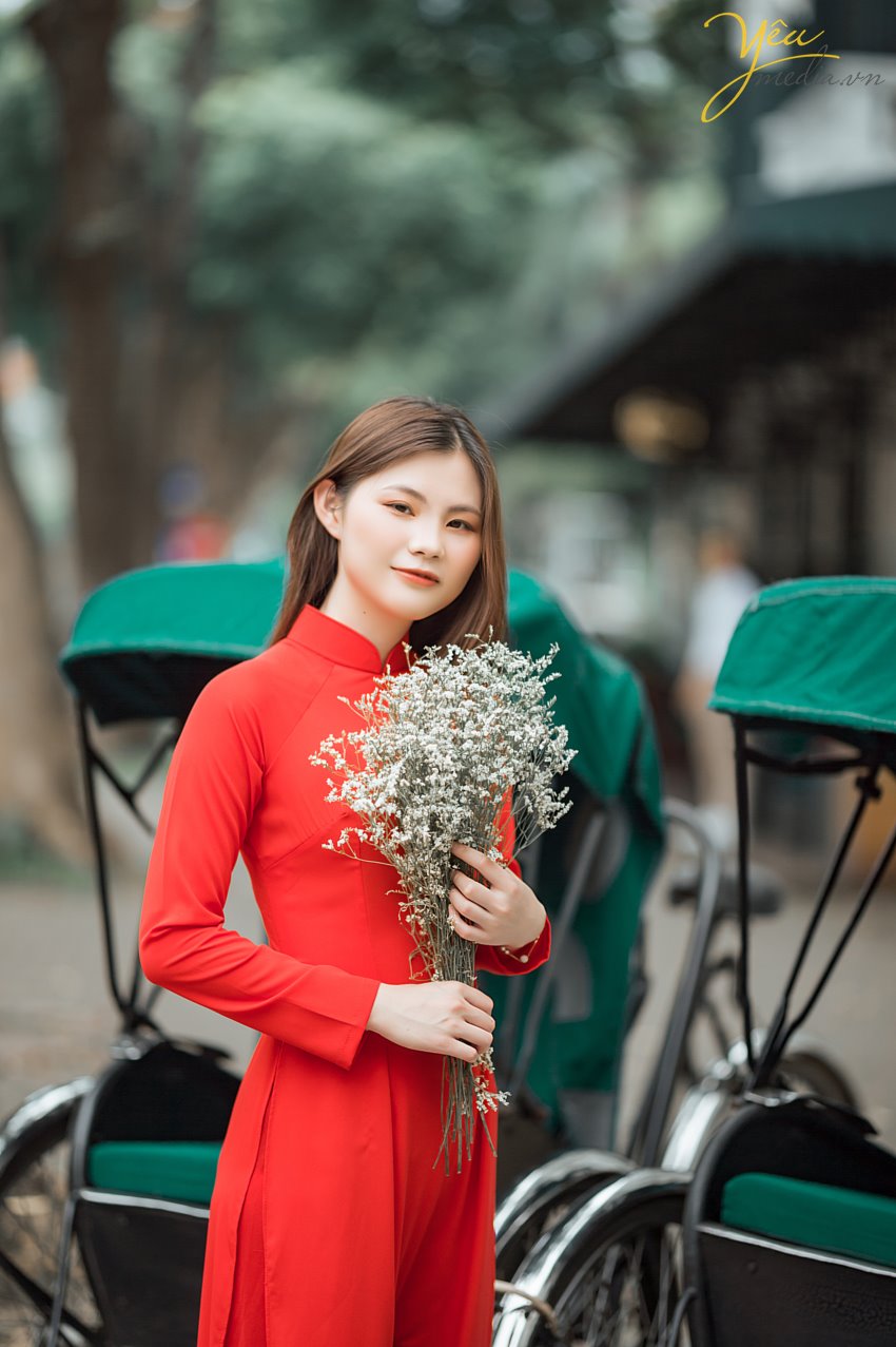 Taking photos of Vietnamese Ao Dai is a trend that many tourists love. To choose a professional, enthusiastic, and passionate photography studio, customers from all over the world, such as Korea, China, Japan, Europe, etc., have chosen Yeumedia studio. Coming to Yeumedia, you will be consulted enthusiastically, to make the right decision for your impressive photos. Where to take photos, at what time of day, how to choose the context, how to makeup, how to choose the dress, how to make hairdo ... will all be helped by Yeumedia's team to create the set the most beautiful pictures for you in Hanoi. In Hanoi there are many places suitable for taking traditional costume "Áo Dài" photos for you to choose, for example: Long Bien bridge, the Old Quarter, the Temple of Literature, Dong Xuan market, Sword Lake, etc. Let's take a look at one sample we made for a Chinese Tourist who fell in love with Hanoi and our "Ao Dai": Ms. Xu Dong Dong