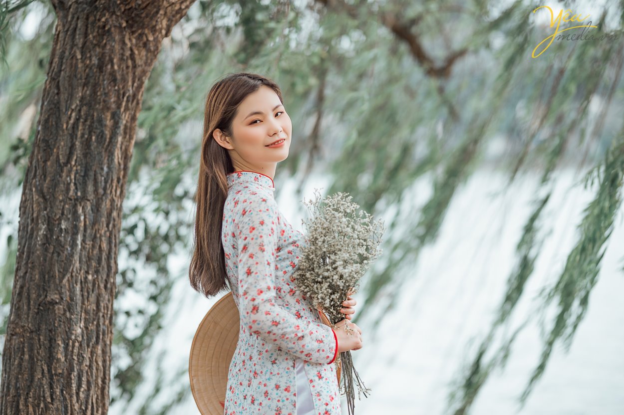 Taking photos of Vietnamese Ao Dai is a trend that many tourists love. To choose a professional, enthusiastic, and passionate photography studio, customers from all over the world, such as Korea, China, Japan, Europe, etc., have chosen Yeumedia studio. Coming to Yeumedia, you will be consulted enthusiastically, to make the right decision for your impressive photos. Where to take photos, at what time of day, how to choose the context, how to makeup, how to choose the dress, how to make hairdo ... will all be helped by Yeumedia's team to create the set the most beautiful pictures for you in Hanoi. In Hanoi there are many places suitable for taking traditional costume "Áo Dài" photos for you to choose, for example: Long Bien bridge, the Old Quarter, the Temple of Literature, Dong Xuan market, Sword Lake, etc. Let's take a look at one sample we made for a Chinese Tourist who fell in love with Hanoi and our "Ao Dai": Ms. Xu Dong Dong