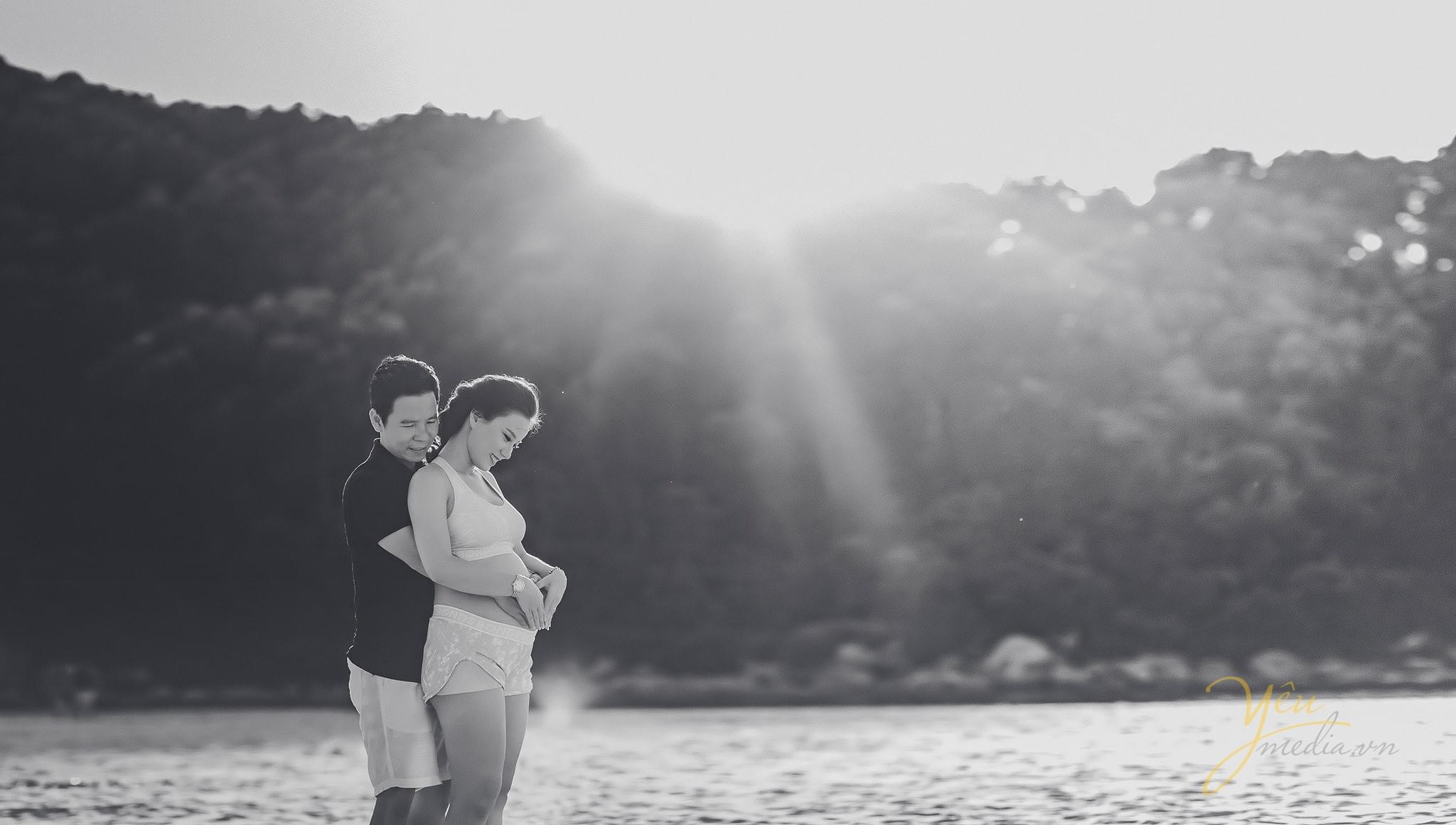 ảnh chụp vợ bầu trên biển chồng ôm từ phía sau vợ