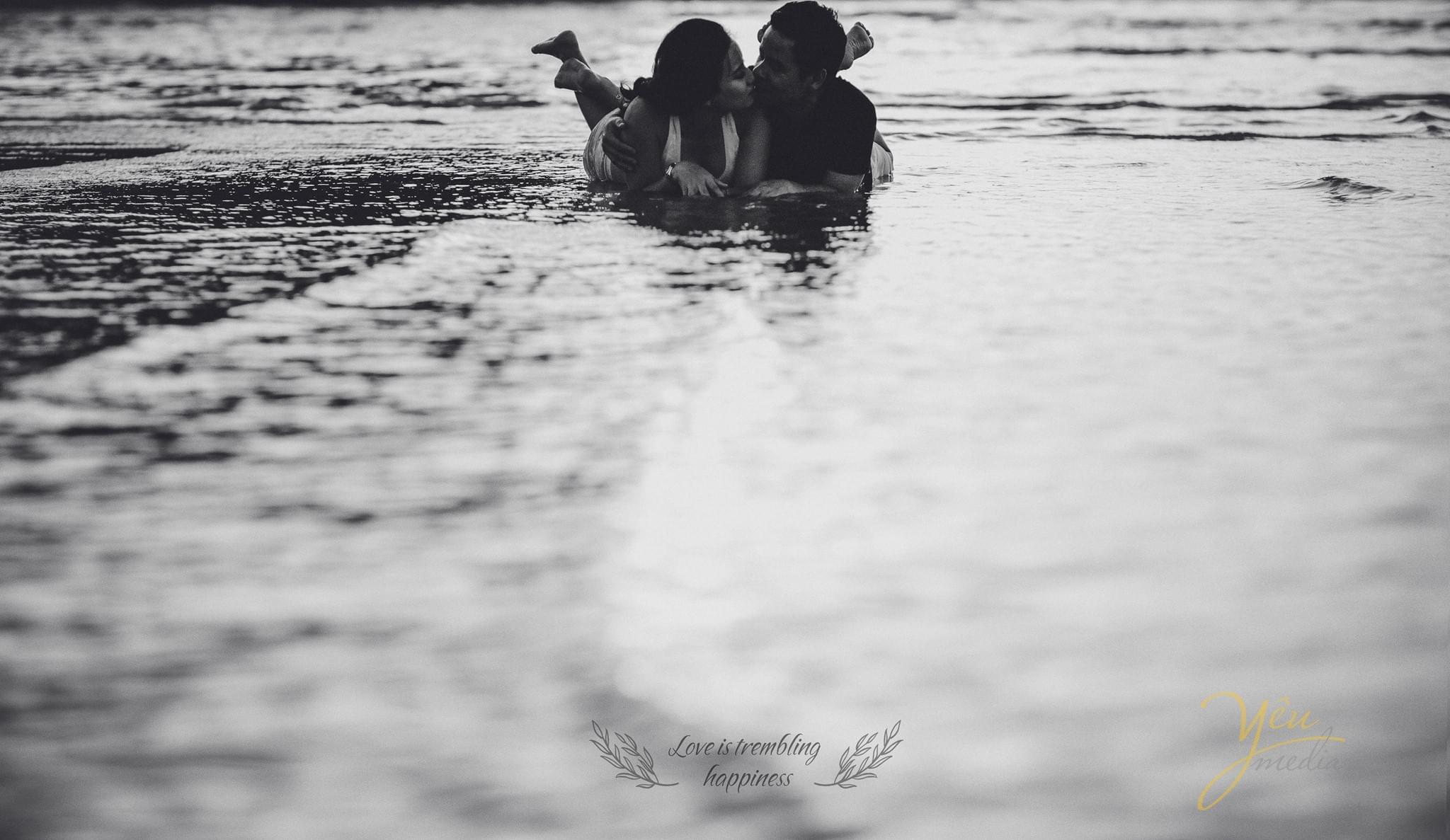 ảnh bầu chụp biển 2 vợ chồng nằm trên bờ biển đen trắng