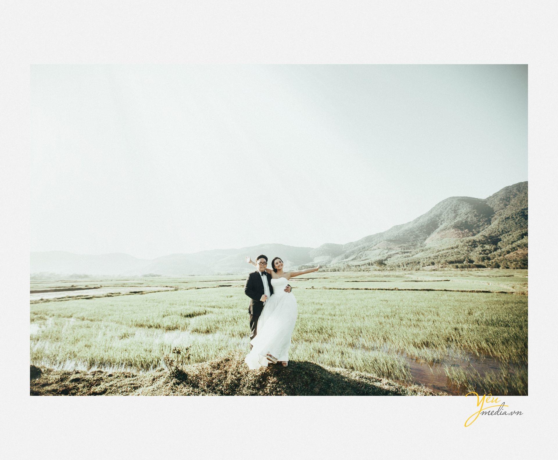 chú rể cô dâu tạo dáng titanic trên đồng cỏ bát ngát