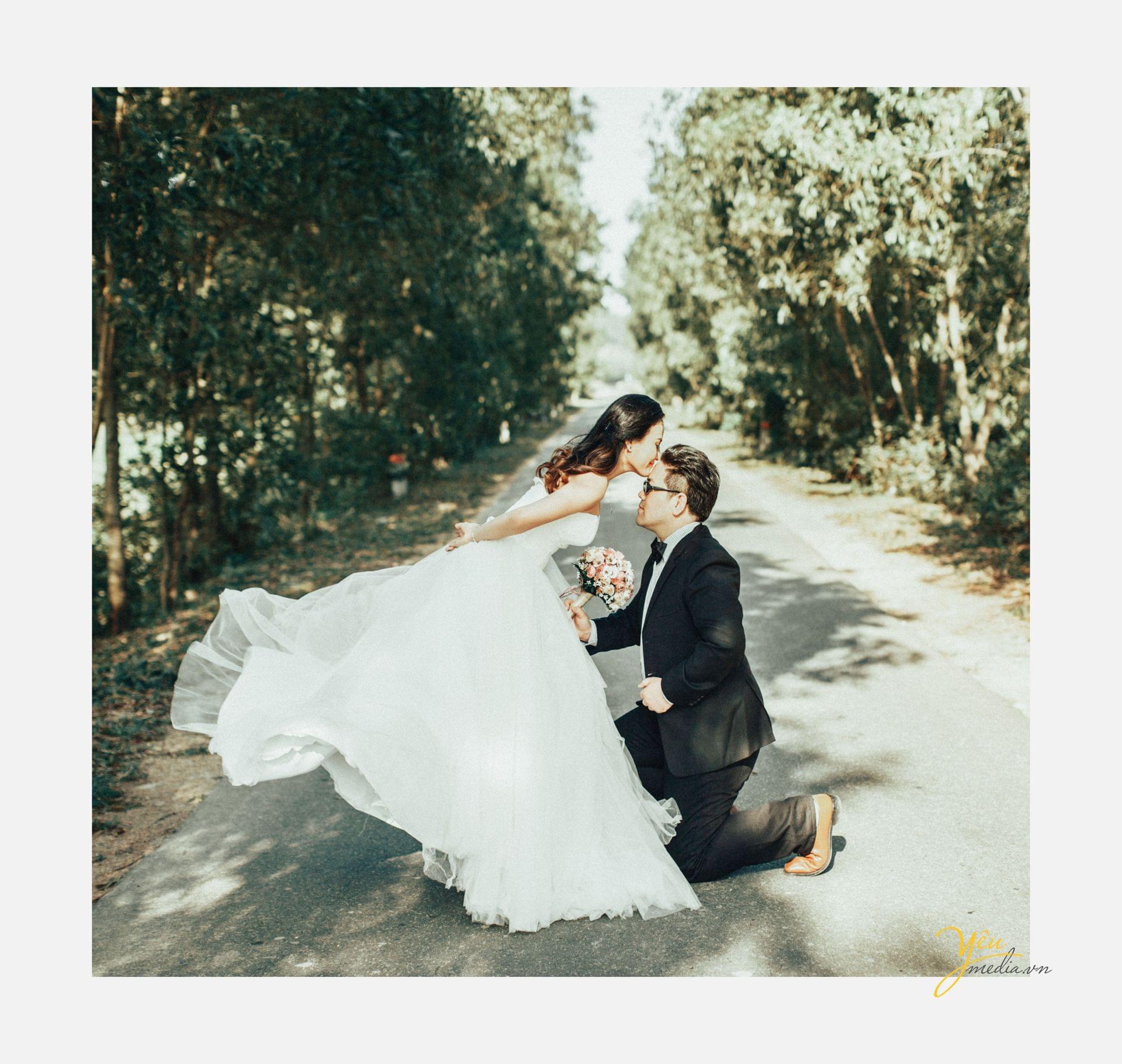 chú rể quỳ dưới chân cô dâu cô dâu hôn trán chú rể