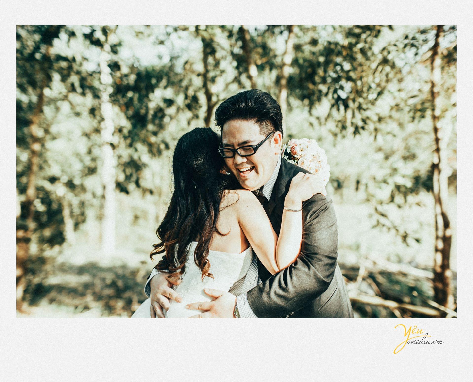 chú rể ôm cô dâu cười trong nắng