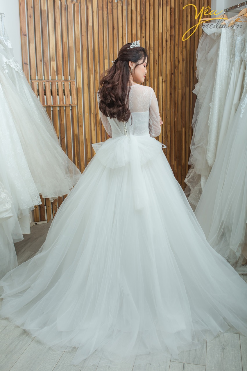 Váy cưới Camille với chất liệu ren sang chảnh nhưng vẫn kín đáo dịu dáng với lớp tay bồng nhẹ dài tay. Phần cúp ngực đầy đặn sẽ tôn vẻ duyên dáng cho mọi cô dâu của Yêu Media.