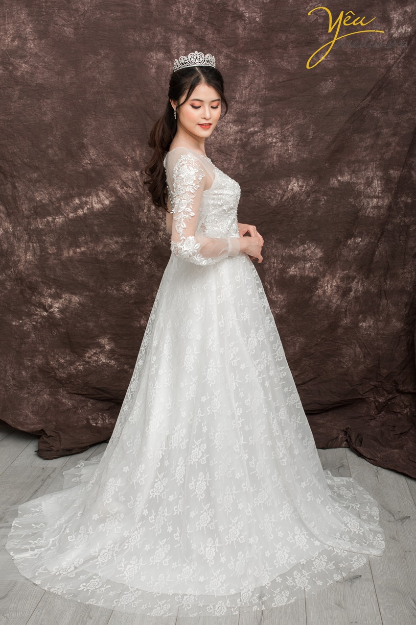 Một chiếc váy nhẹ nhàng và đáng yêu dành cho những cô dâu thích vẻ ngoài hiền thục và nhu mì trong ngày cưới của mình.   Với phần ren nhẹ nhàng, tay dài hơi bồng thoải mái, cúp ngực kín đáo, đai eo sang trọng và phần vải ren thân váy hoa chìm đẳng cấp - đây là chiếc váy đã khiến nhiều cô dâu "Say yes to the dress" của Yêu Media.