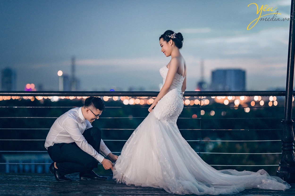 chú rể quỳ xuống buộc dây giầy cho cô dâu