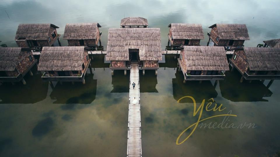 ảnh chụp hồ từ trên cao cô dâu chú rể chạy trên cầu