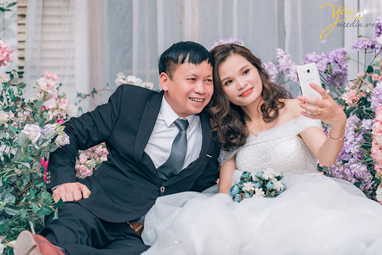 cô dâu chú rể chụp ảnh selfie khi đi chụp phim trường