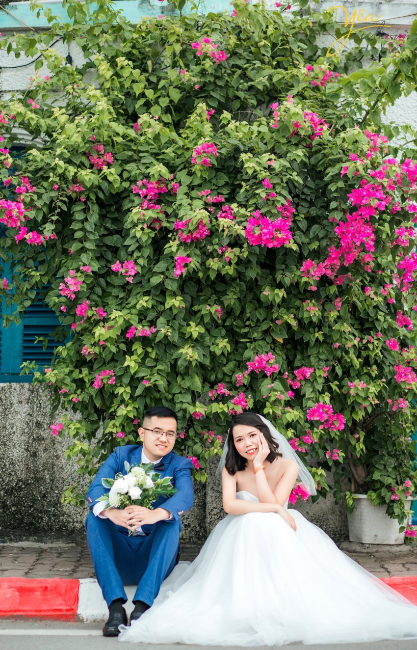 Chụp ảnh cưới ở con đường ven hồ và bến thuyền hồ tây ở Hà Nội được rất nhiều cặp đôi yêu thích. Ở Hồ tây có những góc chụp độc đáo và lãng mạn, đó là con đường lát gạch ven hồ Tây, đó là bến thuyền đầy thơ mộng. Chụp ảnh cưới ở Hồ Tây sẽ mang đến cho các cặp đôi những phút giây hạnh phúc và những bức ảnh vô cùng tuyệt đẹp. Hồ Tây là một trong những hồ rộng lớn và đẹp nhất Hà Nội. Bạn có thể đến với Hồ Tây bằng oto, xe máy, taxi hay xe buyt. Tuy nhiên HongKong Studio khuyên bạn nên đi tới đây bằng xe máy, vì nếu đi bằng oto hoặc taxi, bạn sẽ khó lòng cảm nhận được vẻ mênh mông bát ngát và không khí trong lành ở đây. Đến với Hồ Tây, bạn sẽ bắt gặp rất nhiều góc chụp đẹp bên con đường ven hồ và bến thuyền Hồ Tây. Chúng tuy không sang trọng như những khu nhà biệt thự với kiến trúc độc đáo, chúng cũng không xinh xắn, ngọt ngào như những ngôi nhà gỗ nằm bên giàn hoa tigon mà bạn sẽ bắt gặp khi đi dạo một vòng quanh hồ. Ở con đường ven hồ bên bến thuyền Hồ Tây toát lên vẻ mộc mạc những lại vô cùng quyến rũ. Bạn sẽ không ít hơn một lần tưởng tượng đang đi dưới con đường tình yêu như trong những bộ phim tình cảm Hàn Quốc.