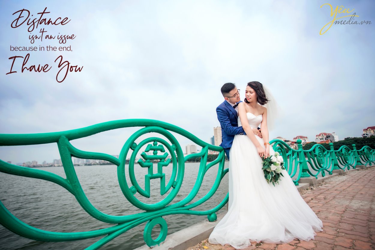 Chụp ảnh cưới ở con đường ven hồ và bến thuyền hồ tây ở Hà Nội được rất nhiều cặp đôi yêu thích. Ở Hồ tây có những góc chụp độc đáo và lãng mạn, đó là con đường lát gạch ven hồ Tây, đó là bến thuyền đầy thơ mộng. Chụp ảnh cưới ở Hồ Tây sẽ mang đến cho các cặp đôi những phút giây hạnh phúc và những bức ảnh vô cùng tuyệt đẹp. Hồ Tây là một trong những hồ rộng lớn và đẹp nhất Hà Nội. Bạn có thể đến với Hồ Tây bằng oto, xe máy, taxi hay xe buyt. Tuy nhiên HongKong Studio khuyên bạn nên đi tới đây bằng xe máy, vì nếu đi bằng oto hoặc taxi, bạn sẽ khó lòng cảm nhận được vẻ mênh mông bát ngát và không khí trong lành ở đây. Đến với Hồ Tây, bạn sẽ bắt gặp rất nhiều góc chụp đẹp bên con đường ven hồ và bến thuyền Hồ Tây. Chúng tuy không sang trọng như những khu nhà biệt thự với kiến trúc độc đáo, chúng cũng không xinh xắn, ngọt ngào như những ngôi nhà gỗ nằm bên giàn hoa tigon mà bạn sẽ bắt gặp khi đi dạo một vòng quanh hồ. Ở con đường ven hồ bên bến thuyền Hồ Tây toát lên vẻ mộc mạc những lại vô cùng quyến rũ. Bạn sẽ không ít hơn một lần tưởng tượng đang đi dưới con đường tình yêu như trong những bộ phim tình cảm Hàn Quốc.
