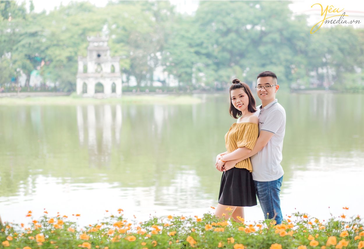 Chụp ảnh cưới ở con đường ven hồ và bến thuyền hồ tây ở Hà Nội được rất nhiều cặp đôi yêu thích. Ở Hồ tây có những góc chụp độc đáo và lãng mạn, đó là con đường lát gạch ven hồ Tây, đó là bến thuyền đầy thơ mộng. Chụp ảnh cưới ở Hồ Tây sẽ mang đến cho các cặp đôi những phút giây hạnh phúc và những bức ảnh vô cùng tuyệt đẹp. Hồ Tây là một trong những hồ rộng lớn và đẹp nhất Hà Nội. Bạn có thể đến với Hồ Tây bằng oto, xe máy, taxi hay xe buyt. Tuy nhiên HongKong Studio khuyên bạn nên đi tới đây bằng xe máy, vì nếu đi bằng oto hoặc taxi, bạn sẽ khó lòng cảm nhận được vẻ mênh mông bát ngát và không khí trong lành ở đây. Đến với Hồ Tây, bạn sẽ bắt gặp rất nhiều góc chụp đẹp bên con đường ven hồ và bến thuyền Hồ Tây. Chúng tuy không sang trọng như những khu nhà biệt thự với kiến trúc độc đáo, chúng cũng không xinh xắn, ngọt ngào như những ngôi nhà gỗ nằm bên giàn hoa tigon mà bạn sẽ bắt gặp khi đi dạo một vòng quanh hồ. Ở con đường ven hồ bên bến thuyền Hồ Tây toát lên vẻ mộc mạc những lại vô cùng quyến rũ. Bạn sẽ không ít hơn một lần tưởng tượng đang đi dưới con đường tình yêu như trong những bộ phim tình cảm Hàn Quốc.