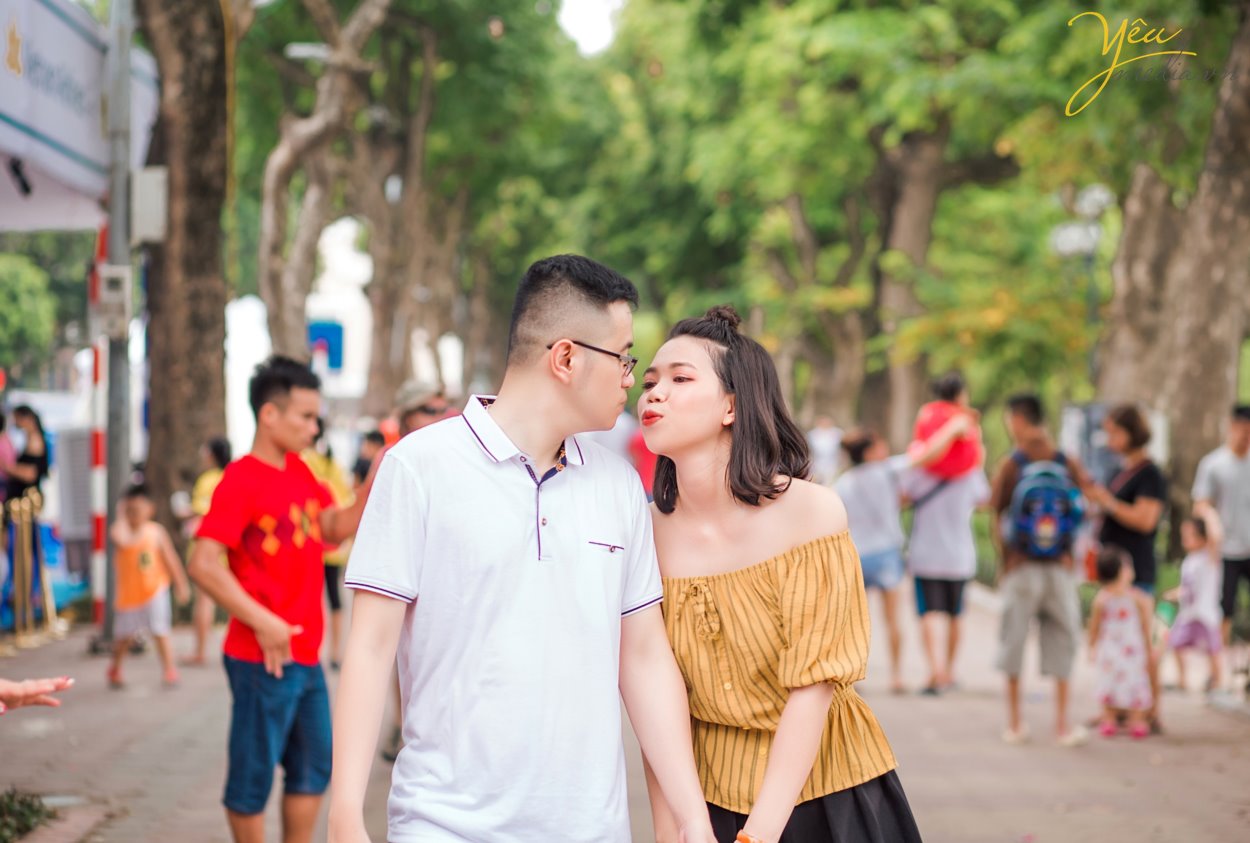 Chụp ảnh cưới ở con đường ven hồ và bến thuyền hồ tây ở Hà Nội được rất nhiều cặp đôi yêu thích. Ở Hồ tây có những góc chụp độc đáo và lãng mạn, đó là con đường lát gạch ven hồ Tây, đó là bến thuyền đầy thơ mộng. Chụp ảnh cưới ở Hồ Tây sẽ mang đến cho các cặp đôi những phút giây hạnh phúc và những bức ảnh vô cùng tuyệt đẹp. Hồ Tây là một trong những hồ rộng lớn và đẹp nhất Hà Nội. Bạn có thể đến với Hồ Tây bằng oto, xe máy, taxi hay xe buyt. Tuy nhiên HongKong Studio khuyên bạn nên đi tới đây bằng xe máy, vì nếu đi bằng oto hoặc taxi, bạn sẽ khó lòng cảm nhận được vẻ mênh mông bát ngát và không khí trong lành ở đây. Đến với Hồ Tây, bạn sẽ bắt gặp rất nhiều góc chụp đẹp bên con đường ven hồ và bến thuyền Hồ Tây. Chúng tuy không sang trọng như những khu nhà biệt thự với kiến trúc độc đáo, chúng cũng không xinh xắn, ngọt ngào như những ngôi nhà gỗ nằm bên giàn hoa tigon mà bạn sẽ bắt gặp khi đi dạo một vòng quanh hồ. Ở con đường ven hồ bên bến thuyền Hồ Tây toát lên vẻ mộc mạc những lại vô cùng quyến rũ. Bạn sẽ không ít hơn một lần tưởng tượng đang đi dưới con đường tình yêu như trong những bộ phim tình cảm Hàn Quốc.