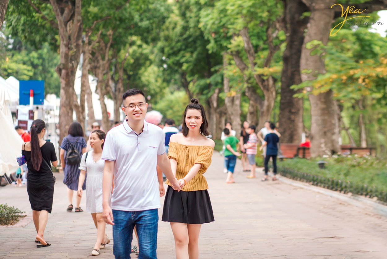 Chụp ảnh cưới ở con đường ven hồ và bến thuyền hồ tây ở Hà Nội được rất nhiều cặp đôi yêu thích. Ở Hồ tây có những góc chụp độc đáo và lãng mạn, đó là con đường lát gạch ven hồ Tây, đó là bến thuyền đầy thơ mộng. Chụp ảnh cưới ở Hồ Tây sẽ mang đến cho các cặp đôi những phút giây hạnh phúc và những bức ảnh vô cùng tuyệt đẹp. Hồ Tây là một trong những hồ rộng lớn và đẹp nhất Hà Nội. Bạn có thể đến với Hồ Tây bằng oto, xe máy, taxi hay xe buyt. Tuy nhiên HongKong Studio khuyên bạn nên đi tới đây bằng xe máy, vì nếu đi bằng oto hoặc taxi, bạn sẽ khó lòng cảm nhận được vẻ mênh mông bát ngát và không khí trong lành ở đây. Đến với Hồ Tây, bạn sẽ bắt gặp rất nhiều góc chụp đẹp bên con đường ven hồ và bến thuyền Hồ Tây. Chúng tuy không sang trọng như những khu nhà biệt thự với kiến trúc độc đáo, chúng cũng không xinh xắn, ngọt ngào như những ngôi nhà gỗ nằm bên giàn hoa tigon mà bạn sẽ bắt gặp khi đi dạo một vòng quanh hồ. Ở con đường ven hồ bên bến thuyền Hồ Tây toát lên vẻ mộc mạc những lại vô cùng quyến rũ. Bạn sẽ không ít hơn một lần tưởng tượng đang đi dưới con đường tình yêu như trong những bộ phim tình cảm Hàn Quốc.
