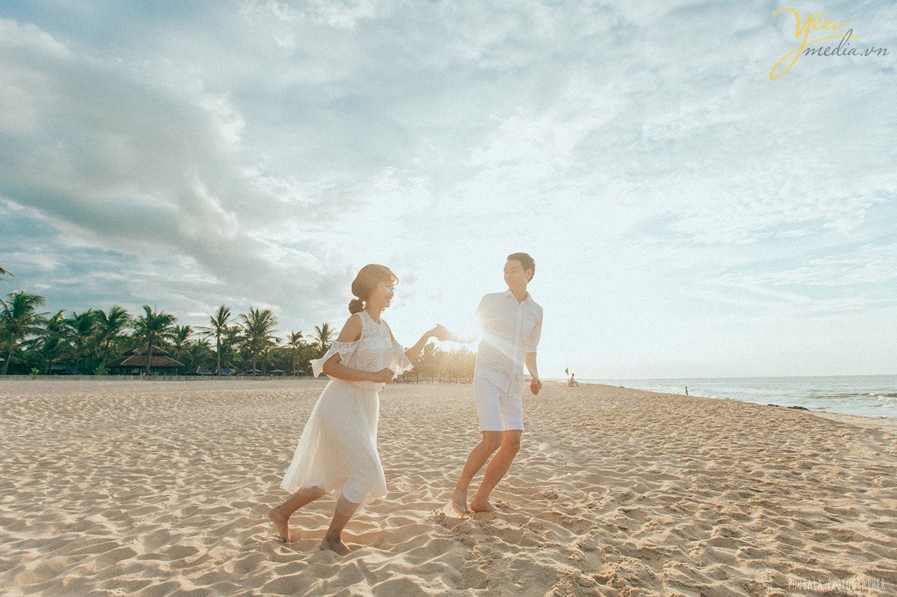 dắt tay nhau đi trên bờ biển