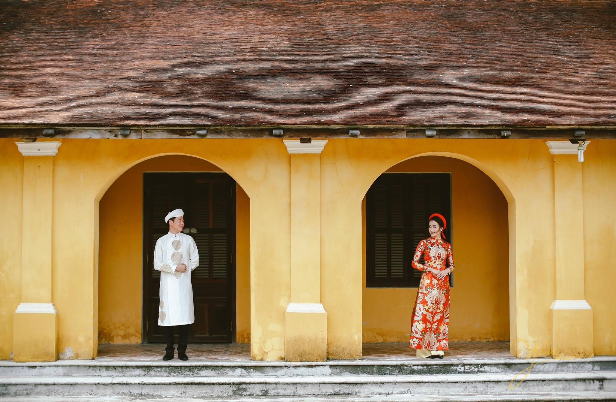 ảnh cưới trang phục áo dài cổ cô dâu chú rể đứng ở hiên nhà cổ