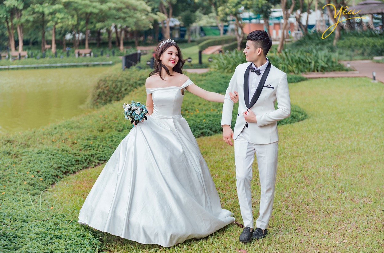 cặp đôi cùng dắt tay nhau đi trong vườn cây xanh