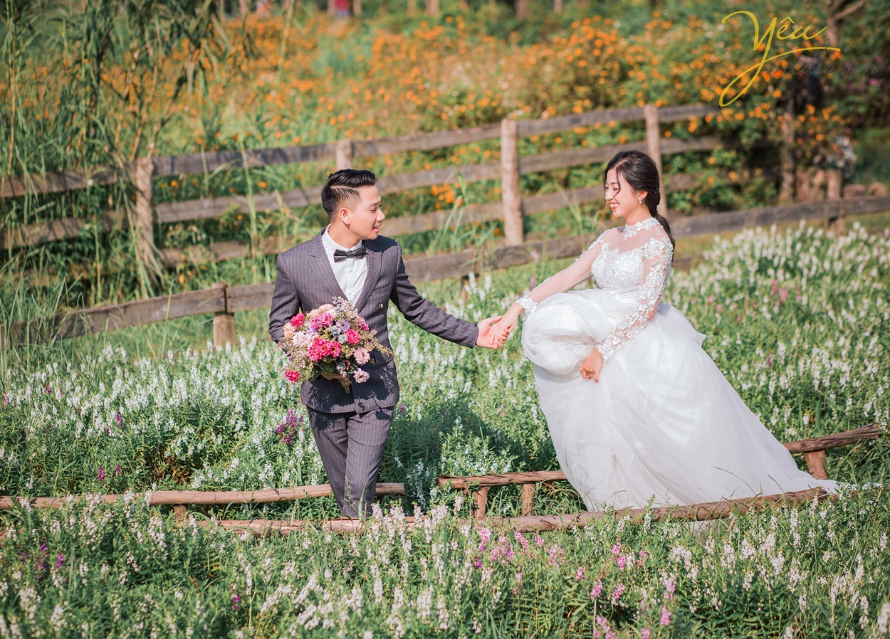 chú rể dắt tay cô dâu đi trong vườn hoa