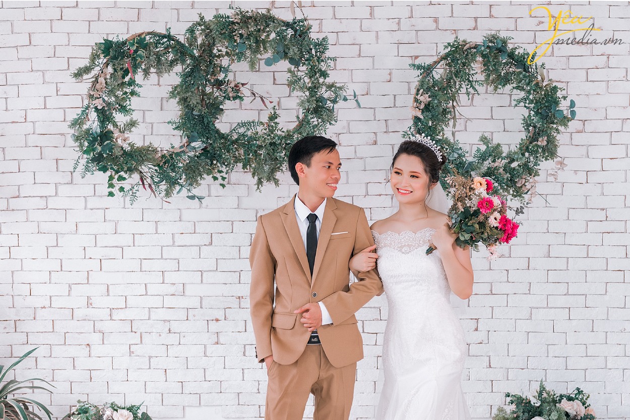 cô dâu khoác tay chú rể trong phim trường