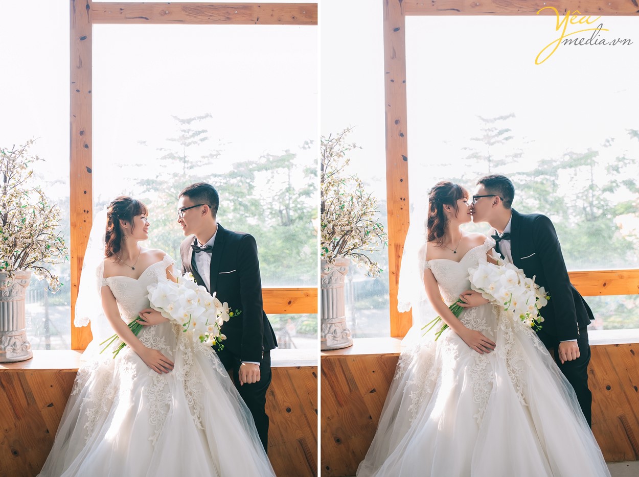 cô dâu chú rể chụp hình bên cửa sổ với ánh nắng đẹp tràn ngập căn phòng