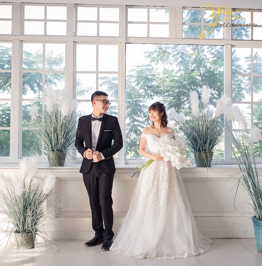 cô dâu chú rể đứng chụp ảnh với ánh sáng tuyệt đẹp tạo album đỉnh cao