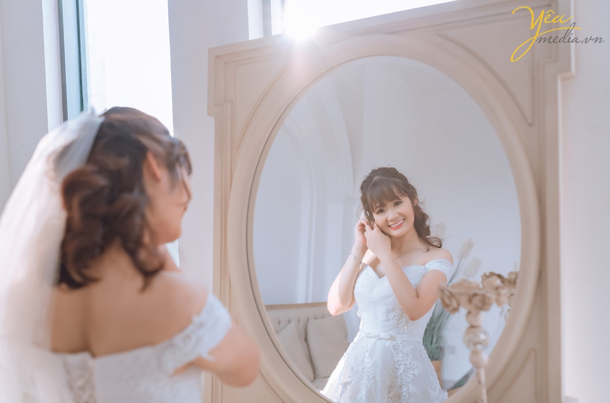 cô dâu xinh soi mình trong gương khi mặc váy cưới