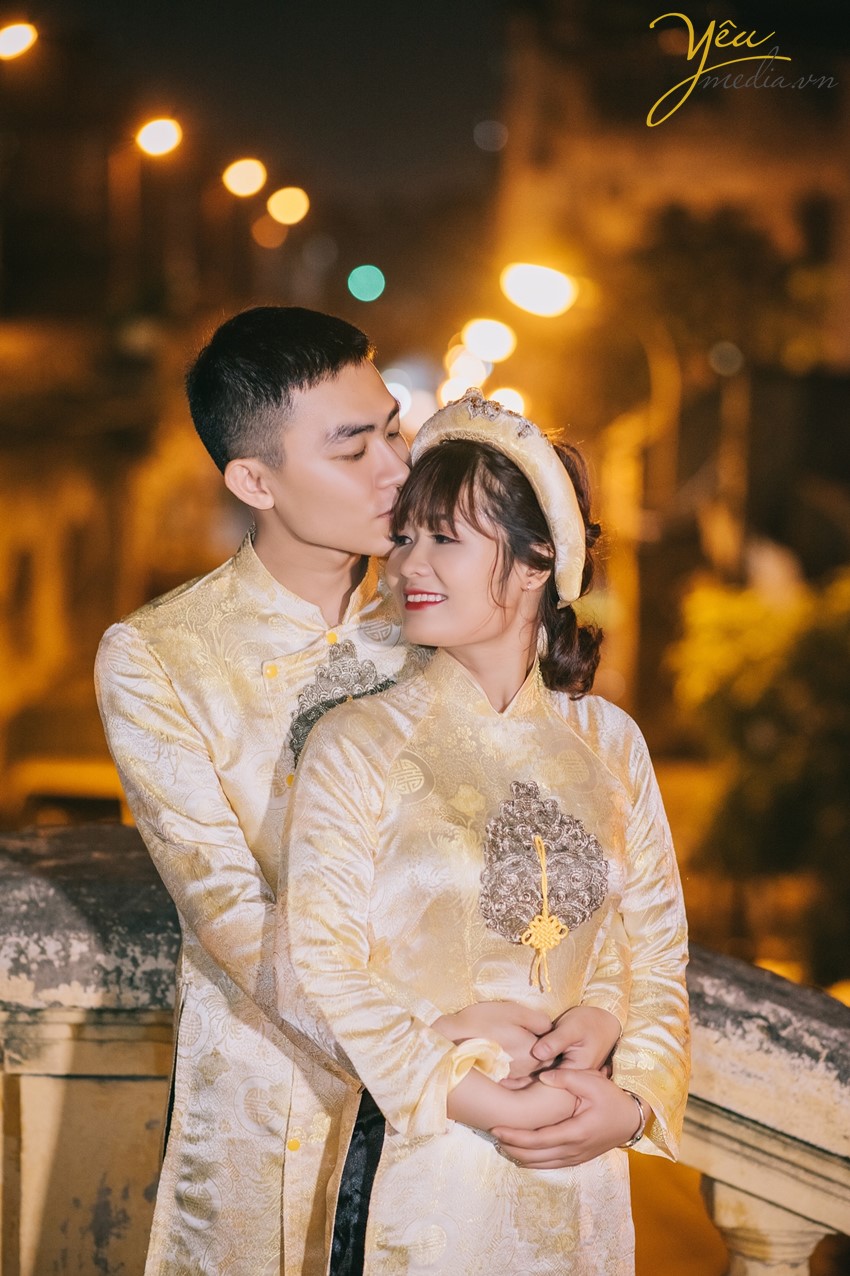 mặc áo dài truyền thống màu vàng chụp ảnh cưới trên cầu long biên