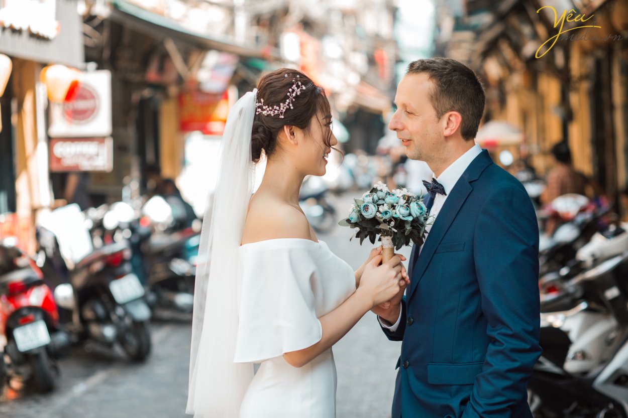 Chụp ảnh cưới ở phố cổ Hà Nội mong tình yêu mãi mãi bền lâu và trường tồn với thời gian. Hà Nội là trái tim của cả nước và chụp ảnh cưới đẹp tại Hà Nội thì không thể không nhắc đến phố cổ, vì nơi đây được xem là trái tim, là linh hồn của Hà Nội.  Khi lựa chọn chụp ảnh cưới ở phố cổ Hà Nội tức là bạn đang lựa chọn cho mình một nơi chụp ảnh cưới ngoại cảnh đẹp tại Hà Nội mang phong cách chụp ảnh cổ điển mà không kém phần hiện đại.  Chú rể Chris người nước ngoài và cô dâu Thảo người Việt Nam đã chọn nơi đây làm địa điểm chụp bộ ảnh cưới có ý nghĩa nhất của cuộc đời mình. Đủ để hiểu trái tim của họ dành cho Hà Nội có 1 tình yêu ngọt ngào và to lớn đến nhường nào.