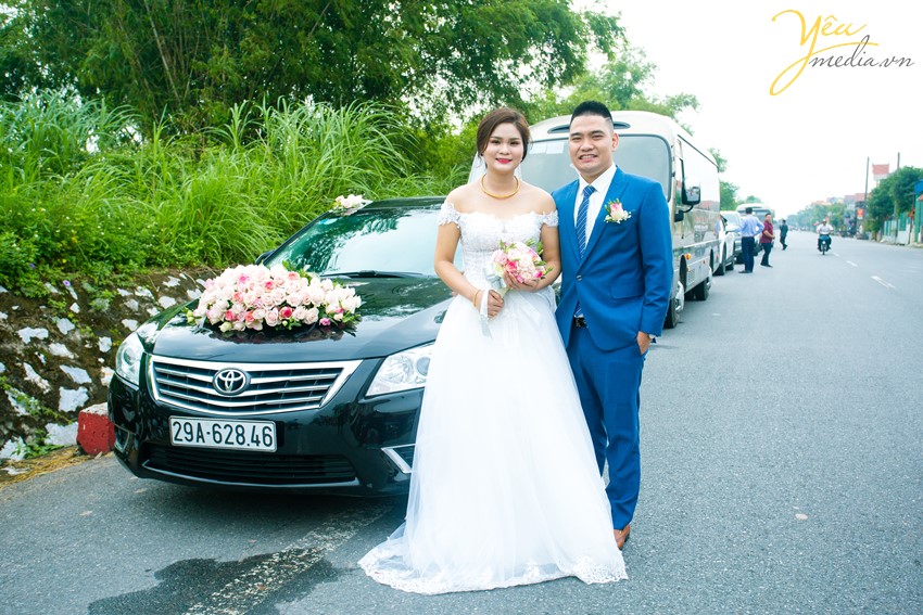 cô dâu chú rể chụp ảnh trước xe rước dâu
