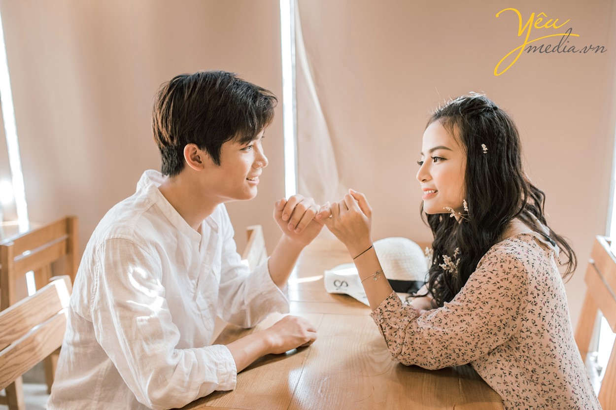 bạn khác giới ngoắc tay nhau trong quán cafe hứa hẹn