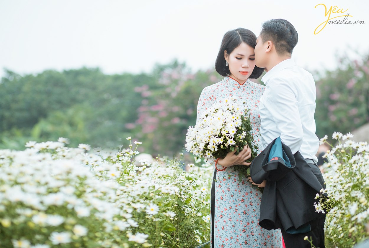hai vợ chồng chụp ảnh ở vườn hoa cúc họa mi tình cảm