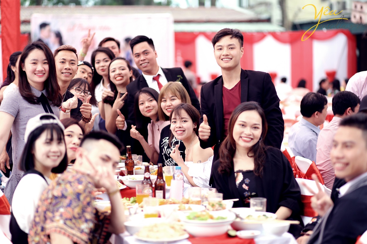 cô dâu chú rể chụp ảnh cùng bạn bè trong lễ cưới