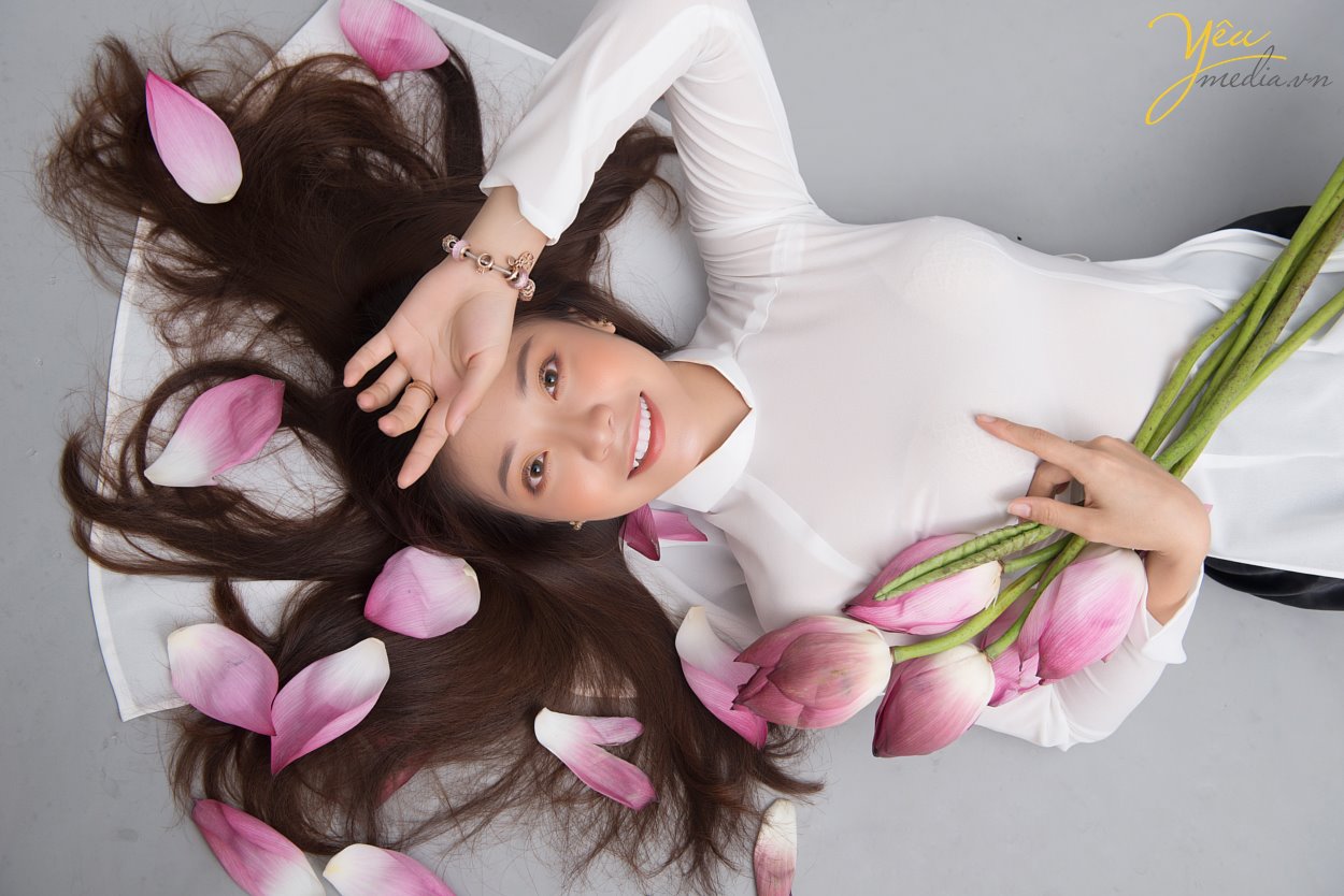 Vì thế, chụp ảnh với sen không chỉ "mê mẩn" giới trẻ mà còn có sức quyến rũ đối với các mỹ nhân Việt từ Bắc tới Nam.  Mỗi người mỗi vẻ khác nhau, nhưng ai cũng chọn cho mình những bộ trang phục đơn giản, không cầu kì để khoe nét đẹp duyên dáng, e ấp. Trang phục áo dài cũng vì thế mà được ưu ái lựa chọn nhiều nhất cho những tấm hình này.   Cặp bạn thân Trà - Min đã chọn Yêu media làm nơi thực hiện bộ ảnh sen cùng áo dài trắng thướt tha của mình. Hãy cùng ngắm bộ ảnh đẹp của các bạn ấy - được chụp tại studio của Yêu media vào tháng 6/2019 nhé!