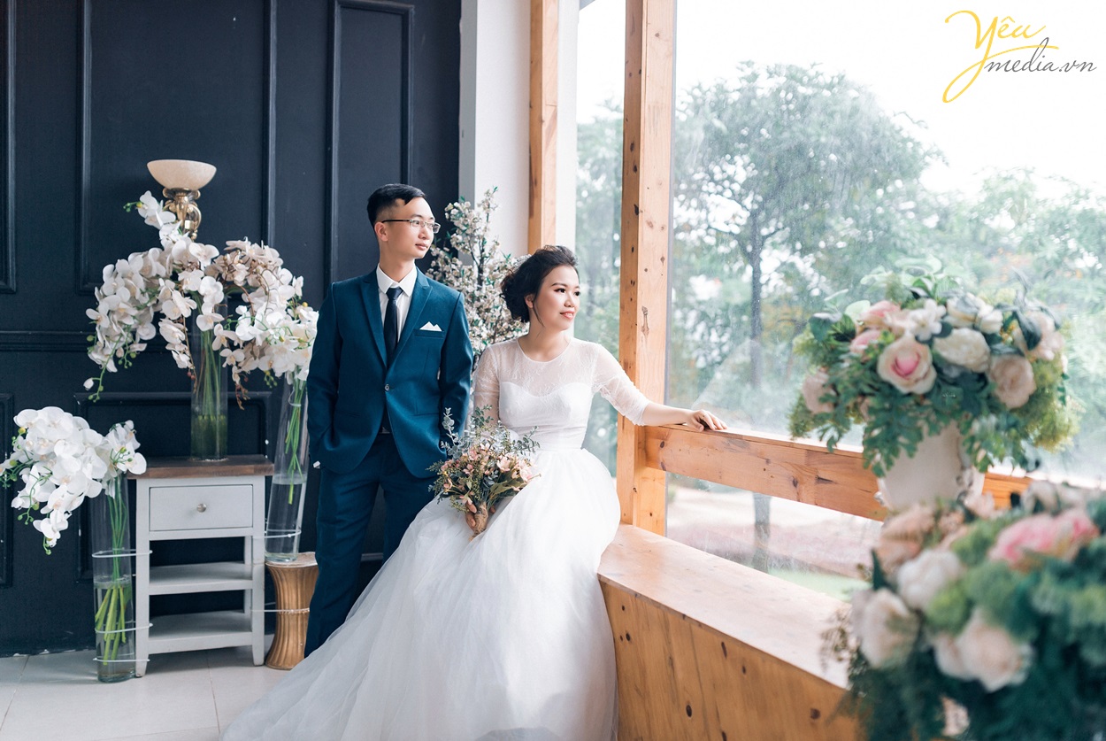 cô dâu chú rể ngồi bên cửa sổ lãng mạn