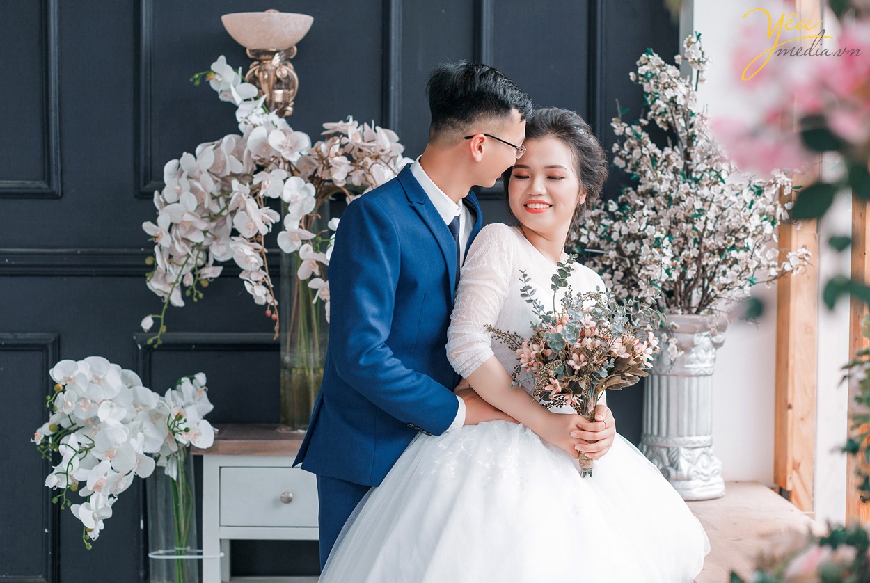 cô dâu chú rể ôm hôn nhau chụp ảnh trong phim trường