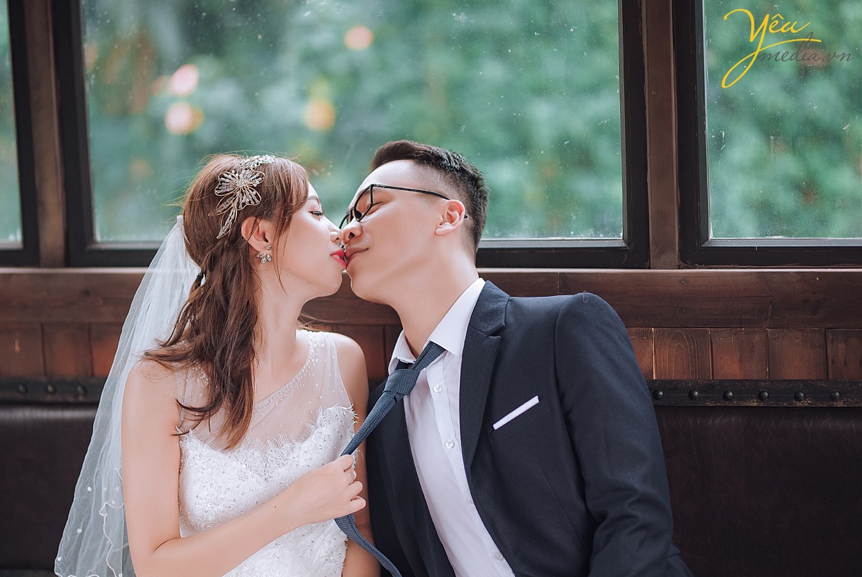 cô dâu chú rể hôn nhau trong ga tàu chụp ảnh