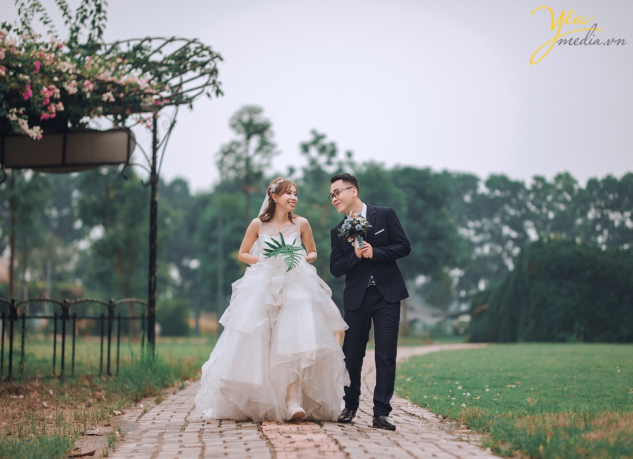 ảnh cưới cô dâu chú rể rảo bước trong vườn