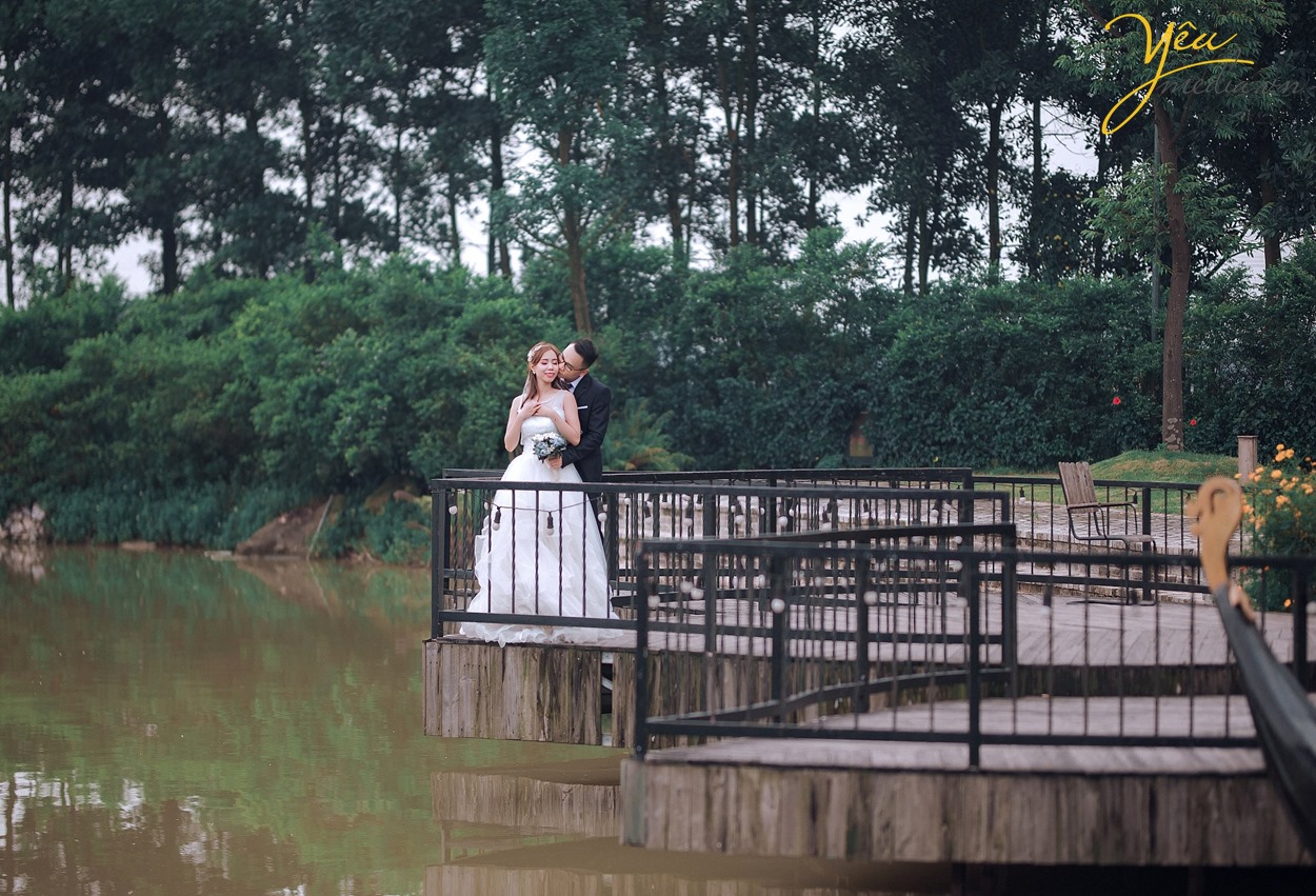 cô dâu chú rể ôm hôn nhau bên hồ