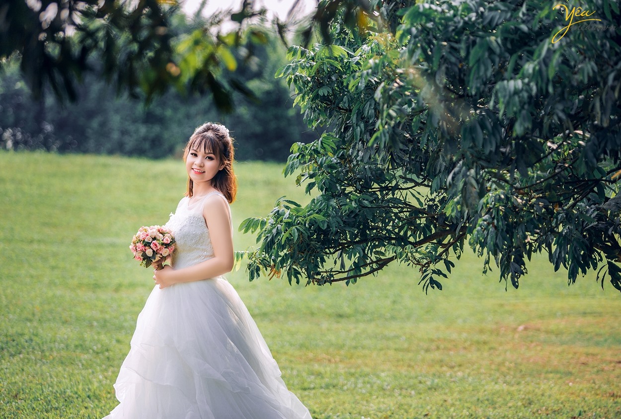 cô dâu xinh trong khu vườn cây xanh lá