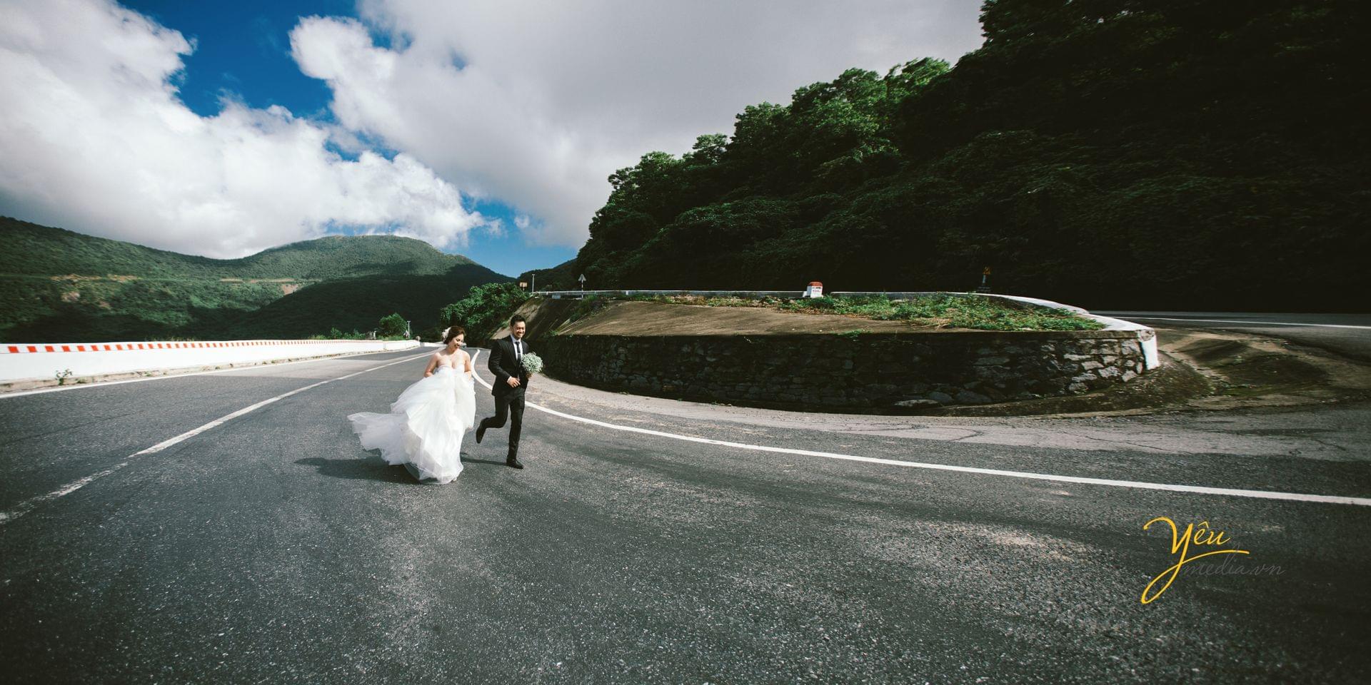 ảnh cưới cô dâu chú rể chạy trên đường lên đỉnh đèo hải vân