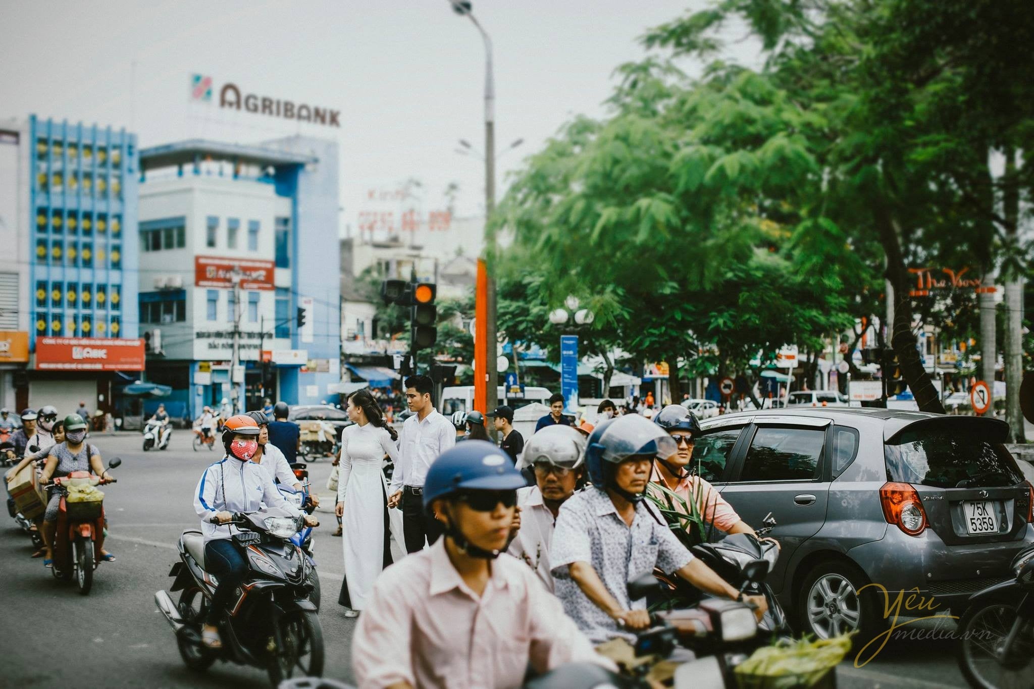 cùng dắt nhau qua con đường tấp nập người qua lại