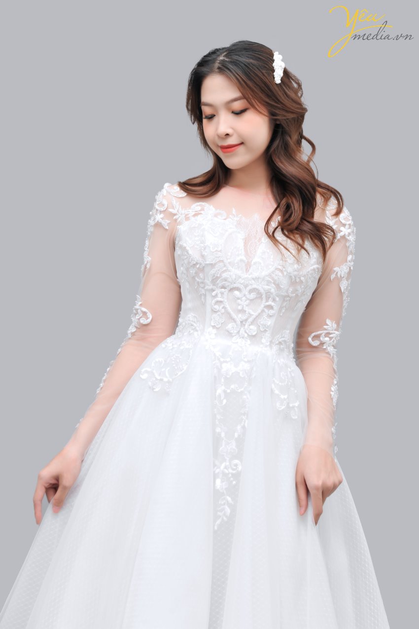 Váy cưới Suri là mẫu tay dài, có họa tiết đính trên thân tay sang trọng. Cúp ngực nhẹ nhàng mà vẫn giữ vẻ kín đáo. Phần lớp váy là tùng 360 độ tạo sự thanh khiết trong từng bước đi cho cô dâu. Chắc chắn các cô dâu mới của Yêu Media sẽ yêu thích mẫu váy này trong thời gian tới!