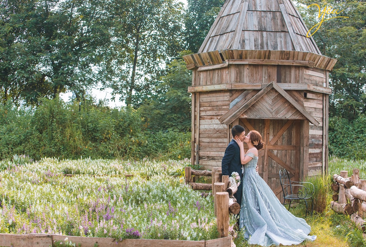 cô dâu chú rể chụp ảnh nắm tay nhau trong vườn